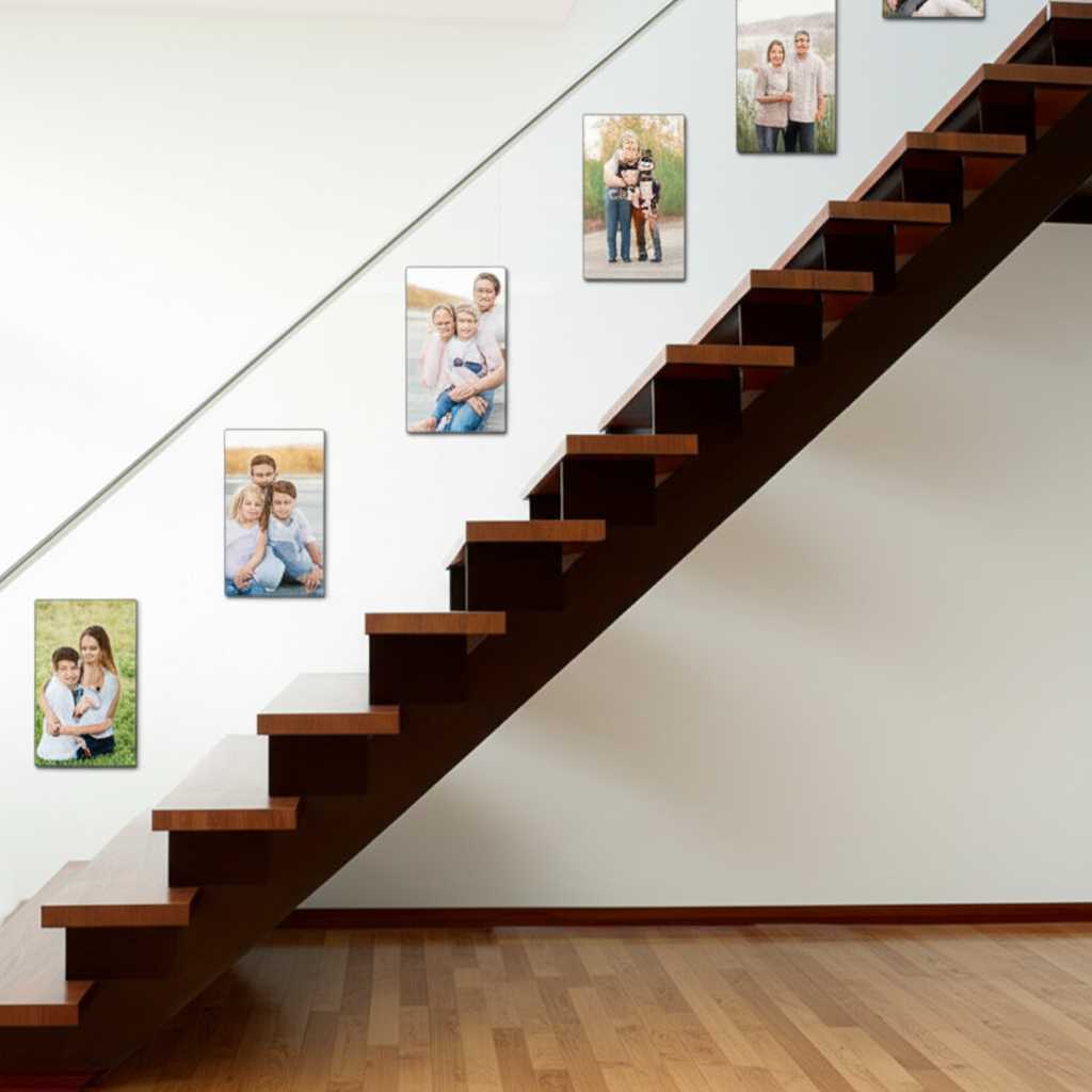 A gallery wall of family photos printed on metal, ascending a modern wooden staircase. The arrangement follows the angle of the stairs perfectly, creating a beautiful flow.