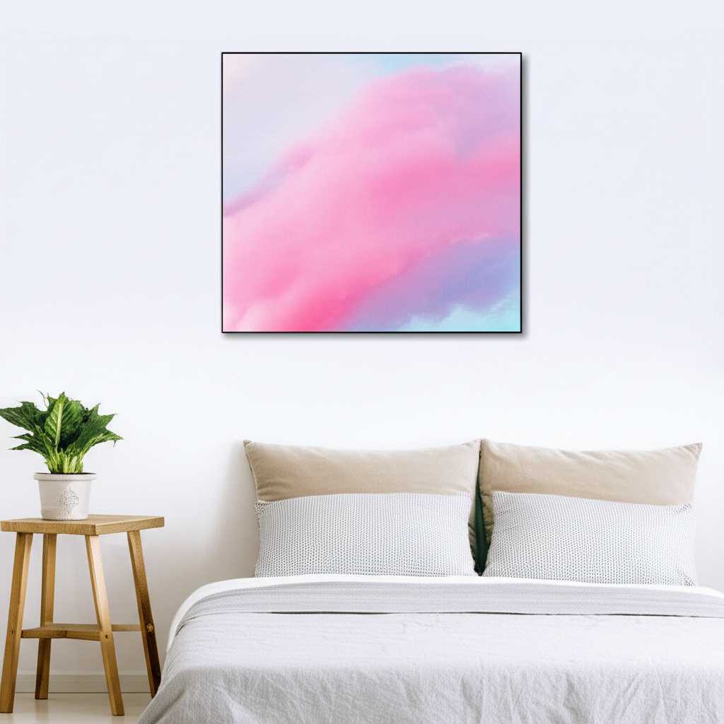 A tranquil bedroom with a single, square metal print of a soft cloudscape hanging above the headboard.