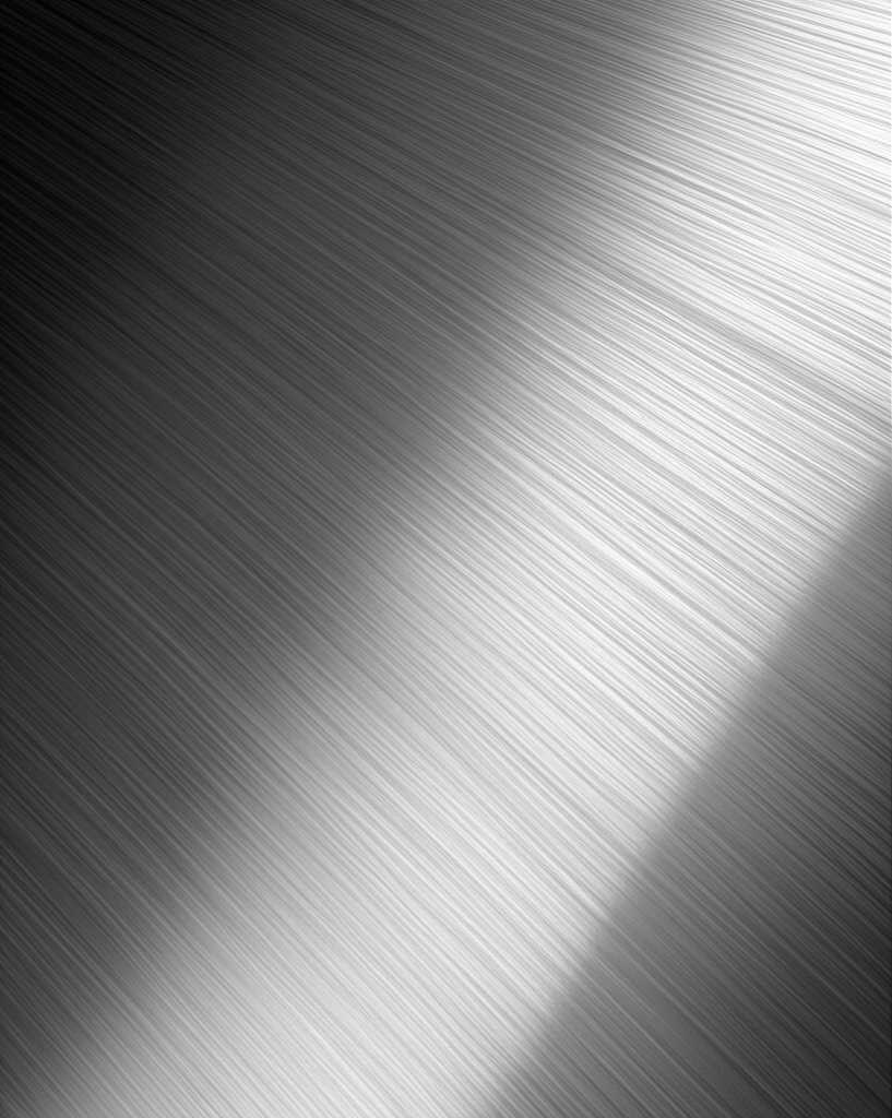 Close-up conceptual image showing light playfully reflecting off a section of a metal print, highlighting both its glossy sheen and subtle underlying texture, without revealing a full artwork.