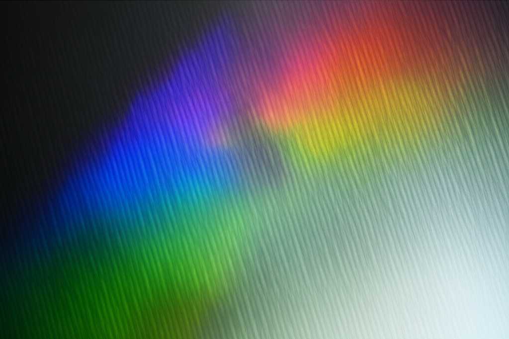 Abstract representation of light interacting with a textured metallic surface, evoking luminosity, depth, and advanced technology.