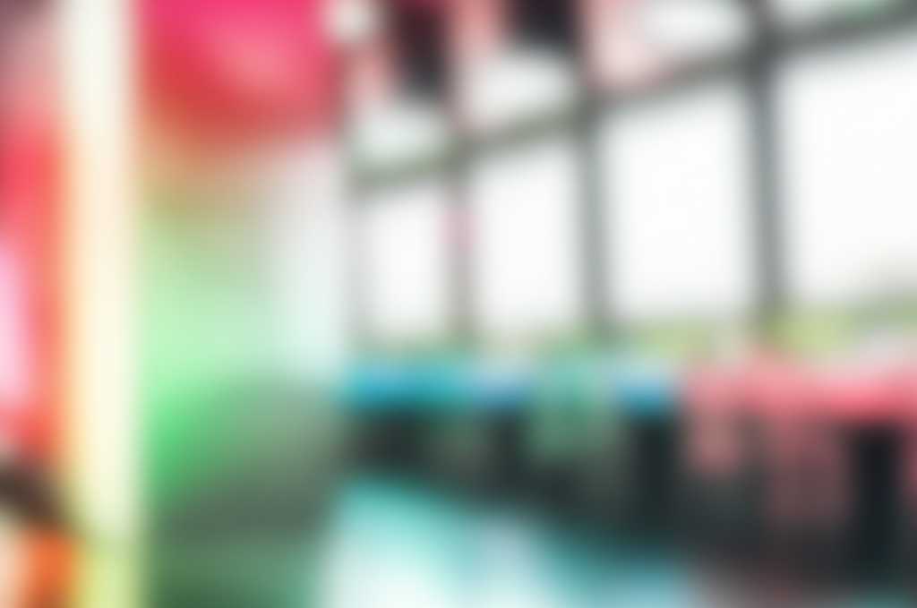 Expansive, dreamlike scene capturing the essence of Impressionist light interacting with a subtly textured, metallic surface, creating a dance of vibrant, diffused colors. No discernible specific artwork, focus on atmosphere and light play. Modern, minimalist interior softly blurred in background.
