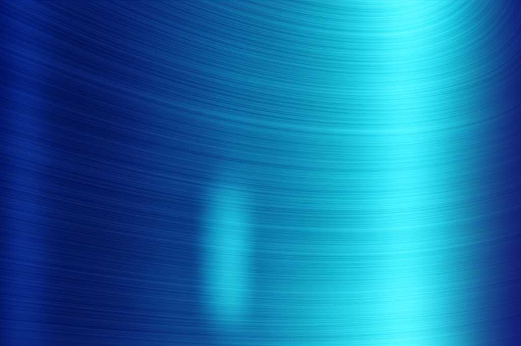 A close-up, side-angle shot showing light reflecting off the glossy, acrylic-like surface of a metal print with subtle texture.