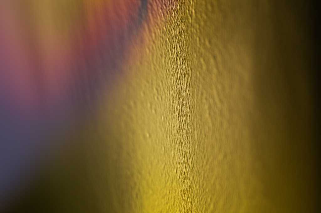 Artistic close-up shot of light reflecting off the textured, glossy surface of a generic metal print